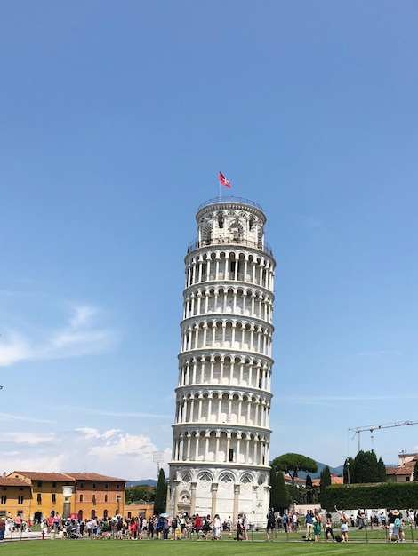 group of people in front of leaning tower against sky
