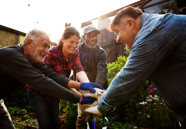 Photo group of people gardening backyard together