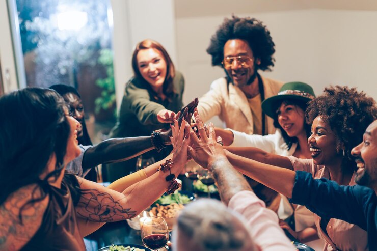 Photo group of people giving high five at the dinner table - colleagues doing team building - friends celebrating