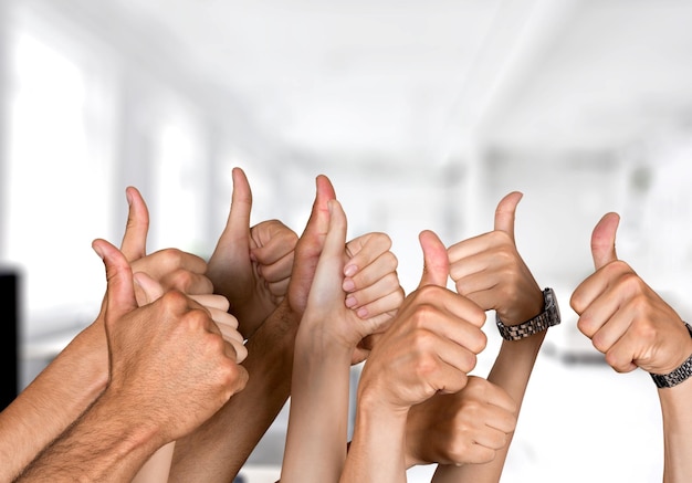 Group of people hands showing thumbs up signs on background