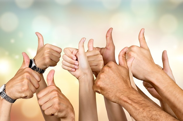 Group of people hands showing thumbs up signs on background