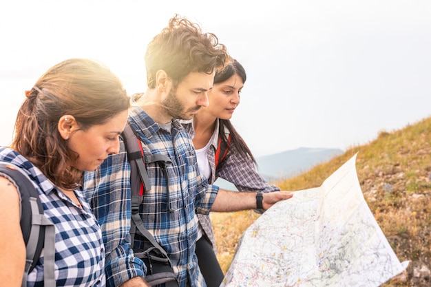 Group of people hiking and looking at map during their adventure