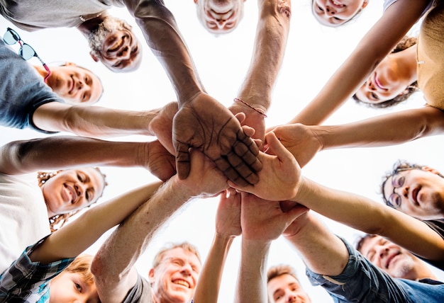 Group of people holding hand assemble togetherness from underneath