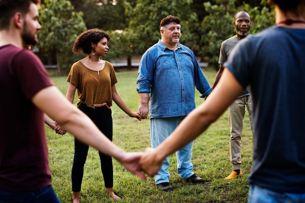 Photo group of people holding hand together in the park