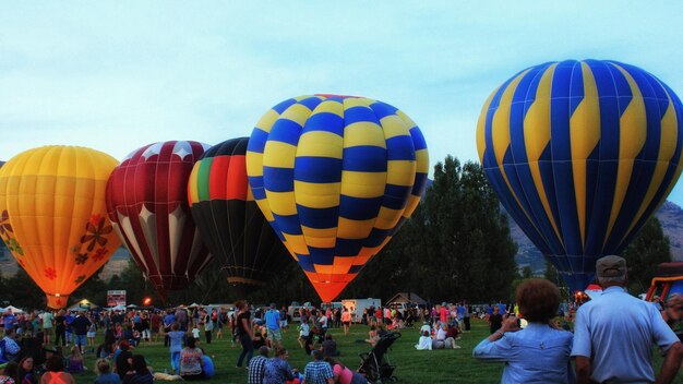 Foto gruppo di persone e palloncini ad aria calda contro il cielo