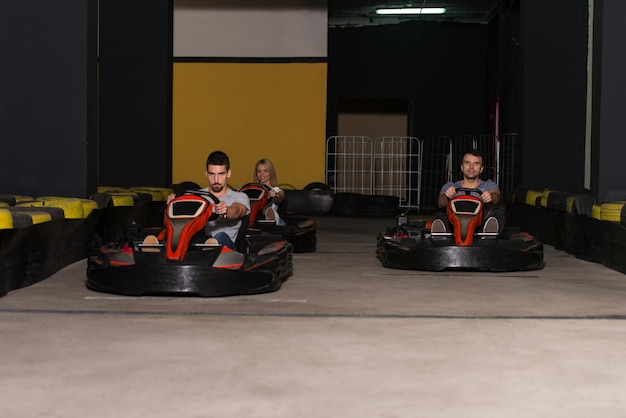 Группа людей за рулем автомобиля GoKart со скоростью на игровой площадке Гоночная трасса Go Kart - популярный вид автоспорта