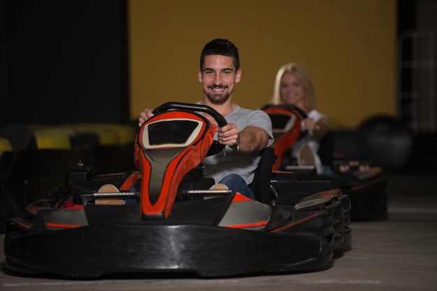 Группа людей за рулем автомобиля GoKart со скоростью на игровой площадке Гоночная трасса Go Kart - популярный вид автоспорта