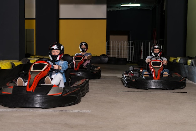 Группа людей за рулем автомобиля GoKart со скоростью на игровой площадке Гоночная трасса Go Kart - популярный вид автоспорта