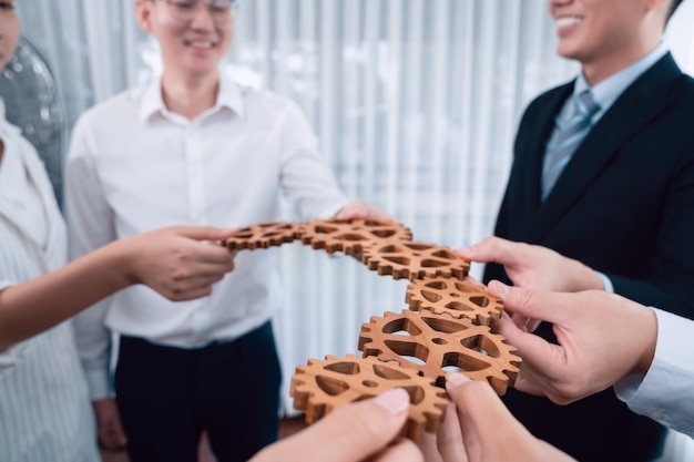 Group of people making chain of gears into collective form for harmony symbol