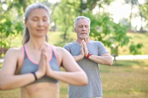 group of people meditating together in park