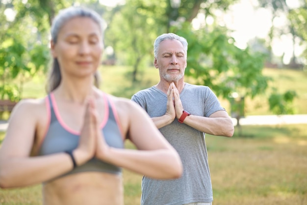 Photo group of people meditating together in park