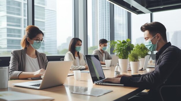 a group of people in a meeting with laptops and plants