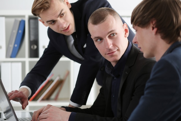 Group of people in office look in laptop