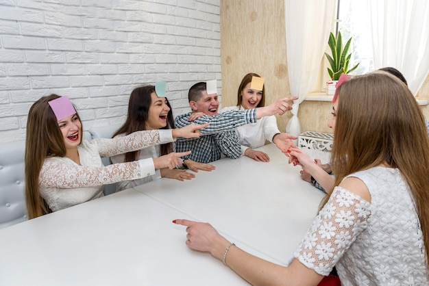 Group of people playing 'Guess who' game in cafe