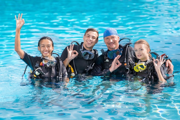 A group of people practice scuba diving in the pool