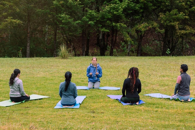 group of people practicing yoga in the forest, meditation practice. mental health.