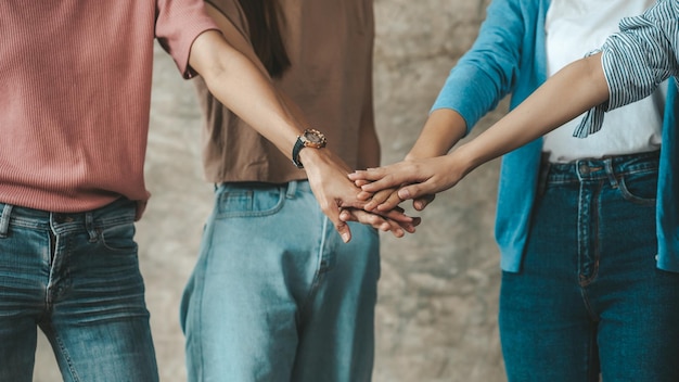 Le persone del gruppo uniscono i pugni donne d'affari joint venture avviare aziende sono giovani imprenditori avviare aziende insieme per gestire un piano per rendere l'azienda redditizia