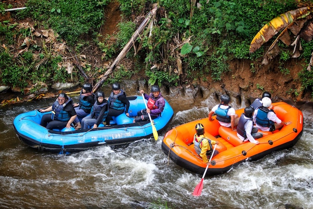 a group of people on rafts with one wearing a life jacket