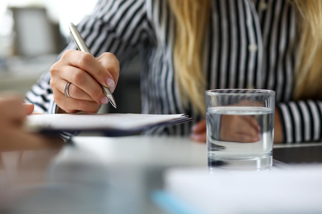 Group of people signing important papers in legal office