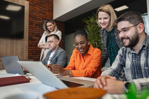 Group of People Sitting Around a Laptop Computer