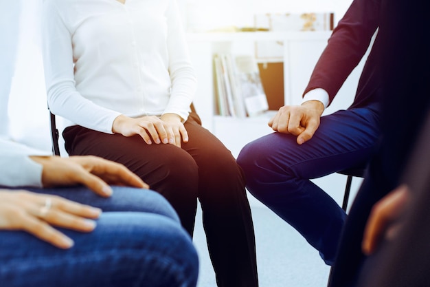 Group of people sitting in a circle during therapy in office. Meeting of business team participating in training.