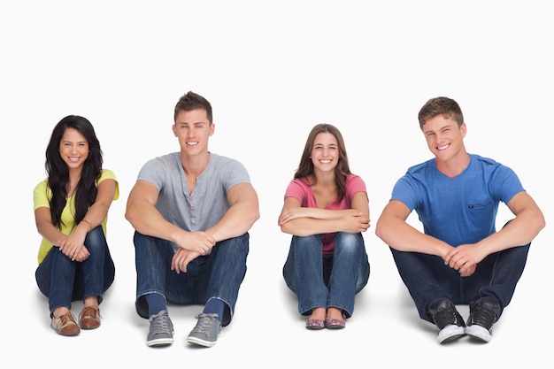 A group of people sitting on the ground together with knees up