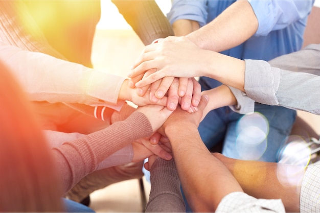 Group of people stacking hands together