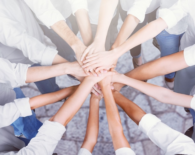 Group of people stacking hands together