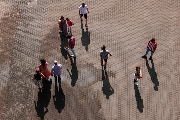 A group of people stand on a sidewalk and look at the camera