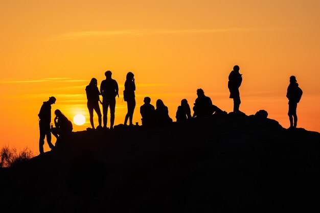 Group of People Standing on Hilltop Overlooking Landscape