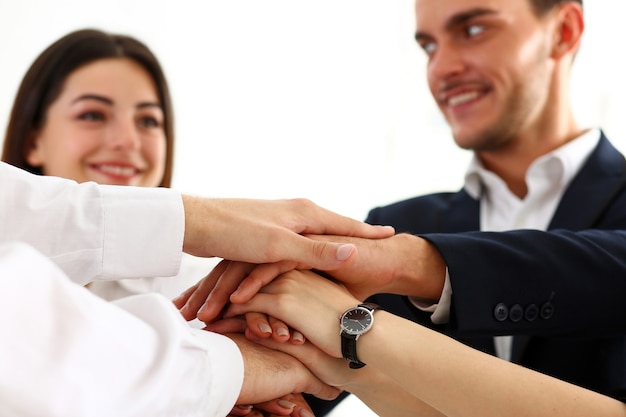 Group of people in suits crossed hands in pile