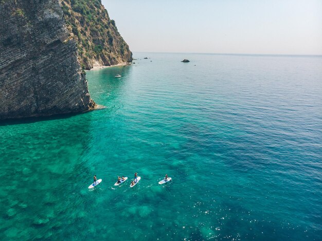 Group of people on surfboard in clear blue sea water