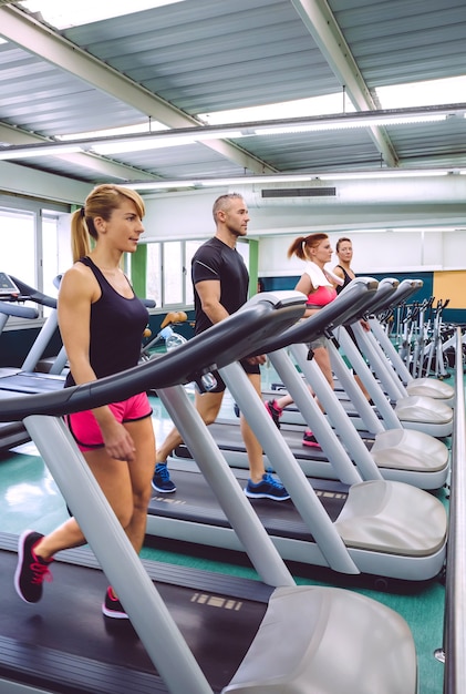 Group of people training over a treadmills on fitness center