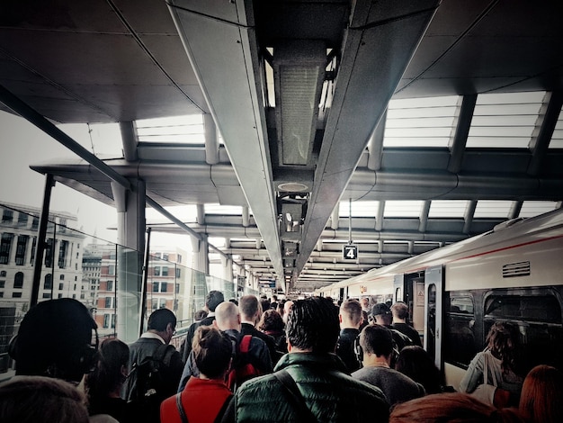 Photo group of people waiting on railroad station platform