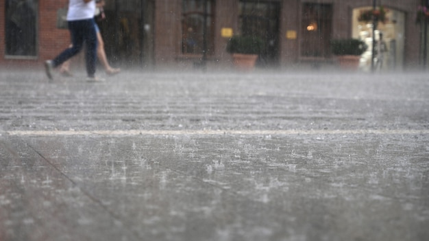 Group of people walking down the street in a rainy day in motion blur