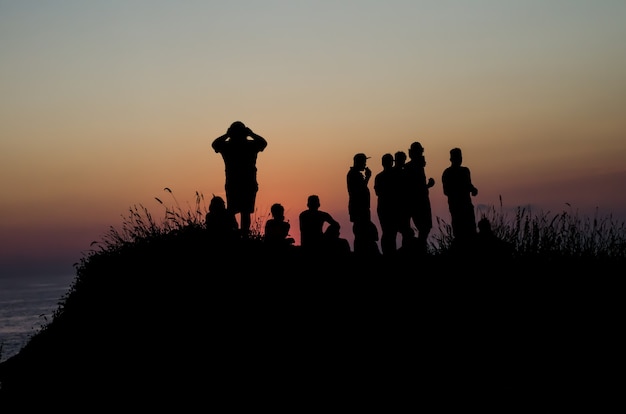 산 꼭대기에서 일몰을 보는 사람들의 그룹