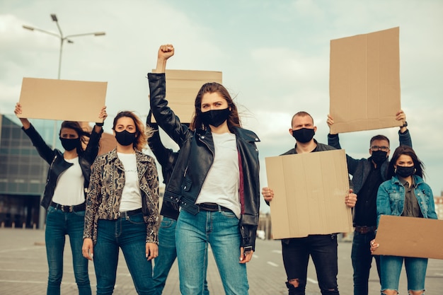 Un gruppo di persone con maschera e poster per protestare la protesta della popolazione contro il coronavirus