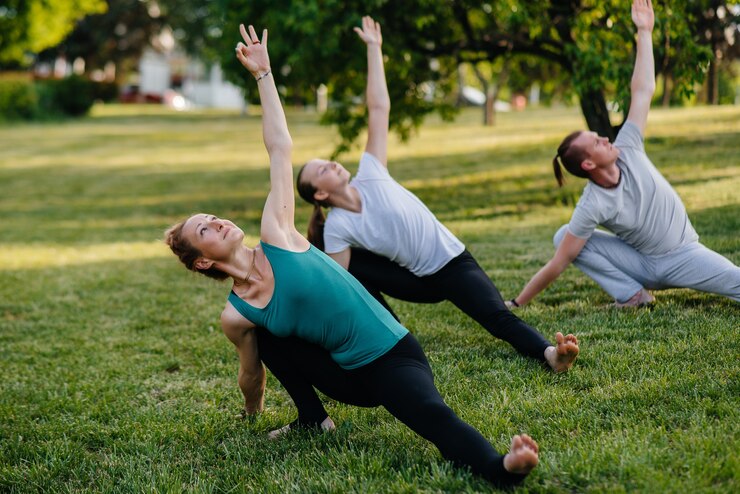 A group of people do yoga in the Park at sunset. Healthy lifestyle, meditation and Wellness.