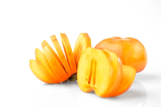 A group of persimmon and sliced  on white background