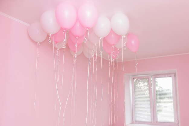 Group of pink and white gel flying balloons on a blue
background home interior