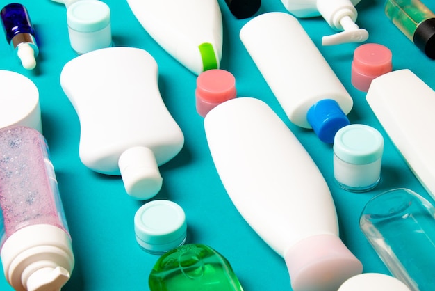 Foto gruppo di bottiglie di plastica per la cura del corpo a strato piatto con prodotti cosmetici su sfondo colorato