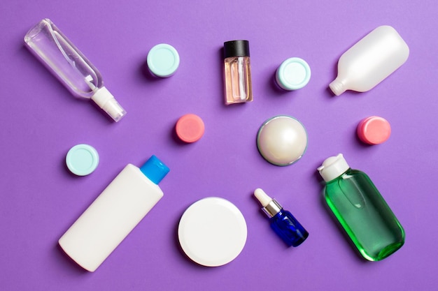 Group of plastic bodycare bottle flat lay composition with cosmetic products on colored background