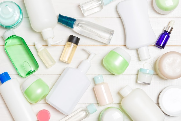 Group of plastic bodycare bottle Flat lay composition with cosmetic products on wooden background empty space for you design. Set of White Cosmetic containers, top view with copy space.