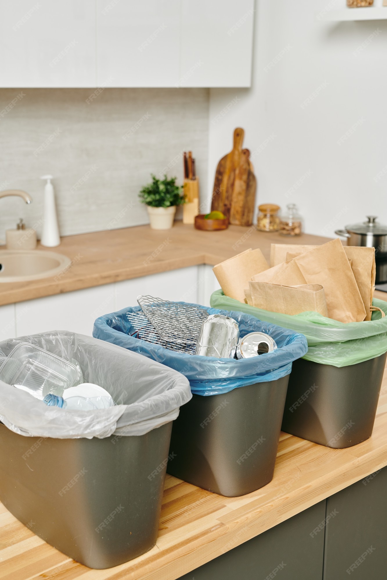 Premium Photo  Group of plastic buckets for waste standign on kitchen table