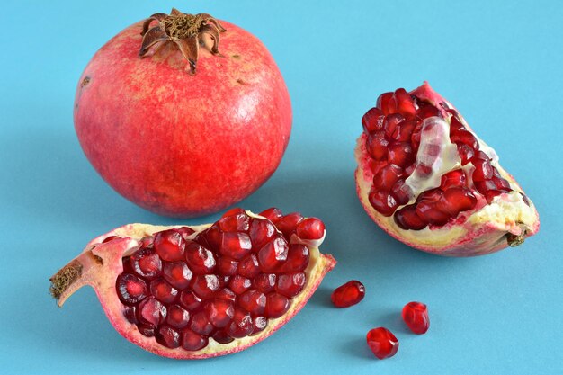 group of pomegranate fruit isolated on blue background, close-up