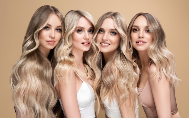 Photo group portrait of four young women with exquisite makeup elegant long hairstyles dyed in the shades