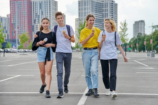 Group portrait of happy teenagers walking together with ice cream