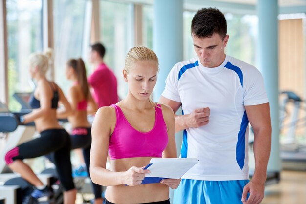 Photo group portrait of healthy and fit young people in fitness gym