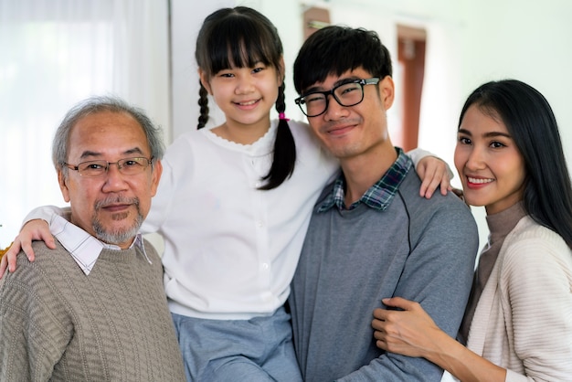 リビングルームに立っている幸せな多世代アジアの家族のグループの肖像画