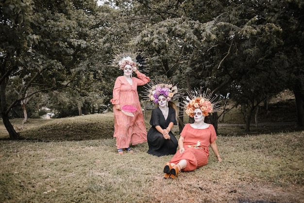 Group portrait of three women with the makeup of the catrinas. Makeup for day of the dead.